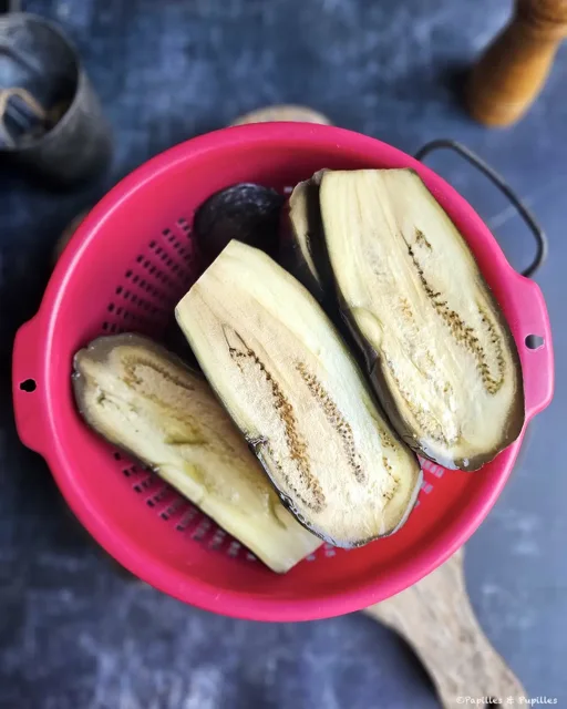 Demi-aubergines cuites égouttées dans une passoire