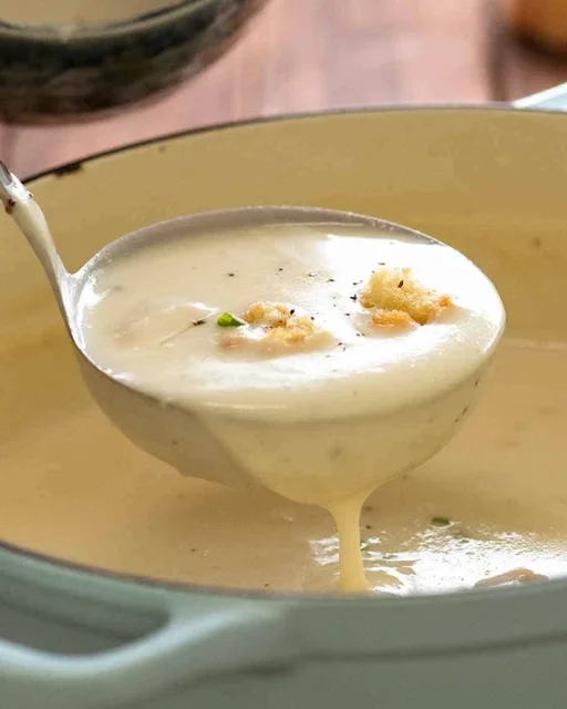 Ladle scooping up thick and creamy Leek Soup from a pot